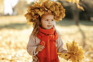  Little girl with a crown of leaves in Autumn outside