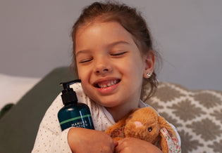  Little girl cuddling her bunny rabbit and a bottle of Manuka Biotic Molluscum  Body Lotion for treating MolluscumContagiosum