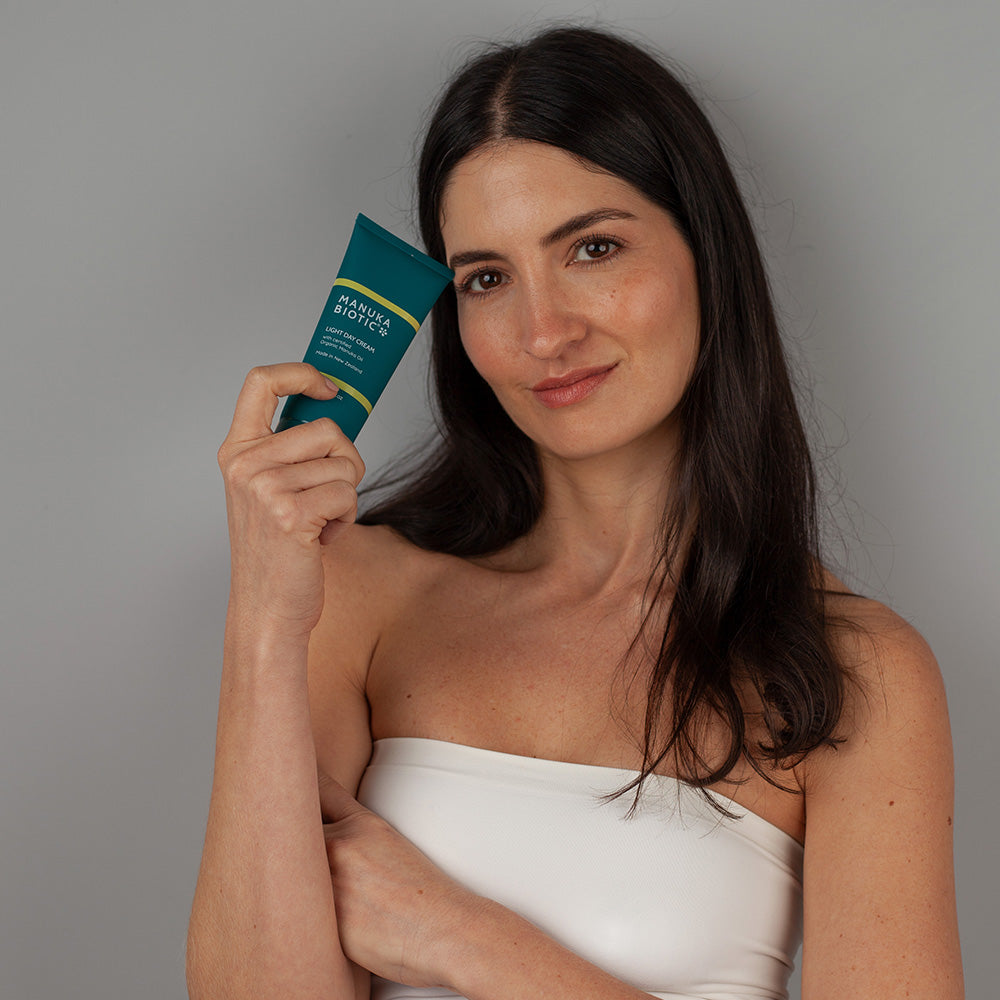  A woman holding a bottle of Manuka Biotic light day cream