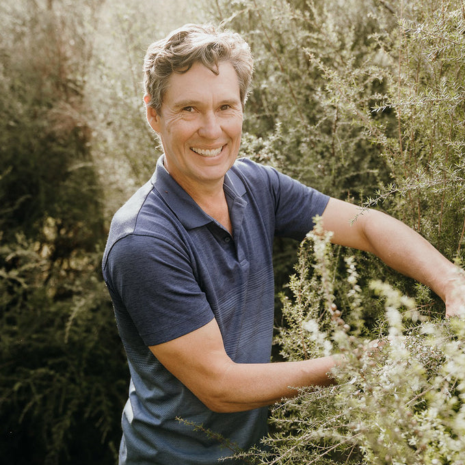  Tim Murray-Leslie smiling into the camera while working on his mānuka farm